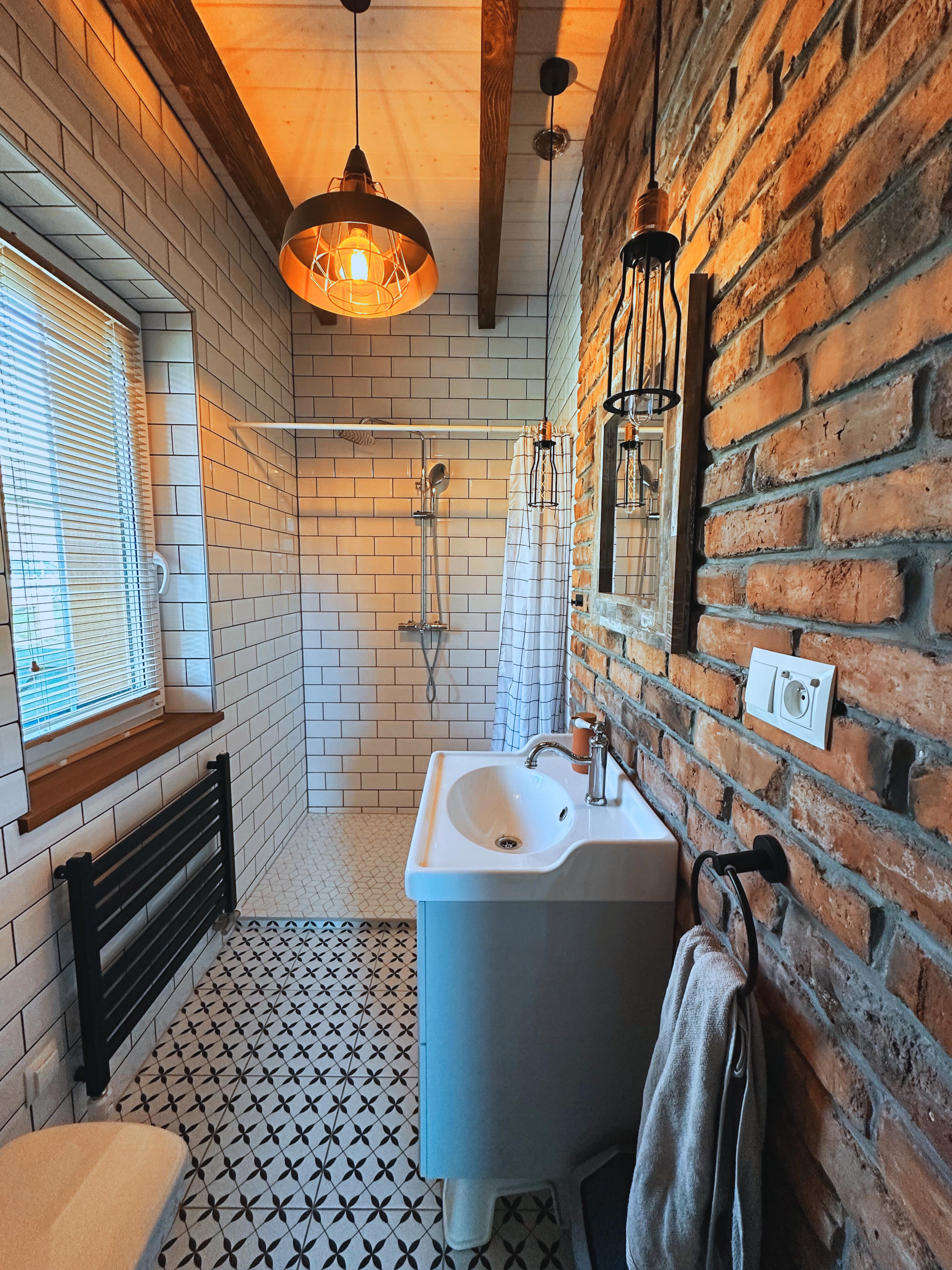 Bathroom with exposed brick wall and patterned floor